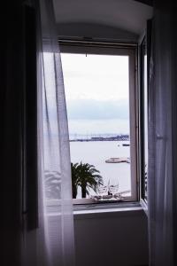 una ventana con vistas al agua y copas de vino en Luxury rooms Skystar-Split, en Split