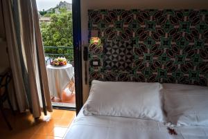 a bedroom with a bed and a balcony with a table at La Moresca in Ravello