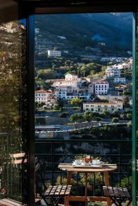 a table on a balcony with a view of a city at La Moresca in Ravello