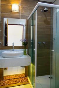 a bathroom with a sink and a glass shower at Pousada Le Baron in Praia do Frances