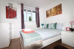 a white bedroom with a bed and a window at Mordern/Luxary 2 BED Flat Near Central London in London