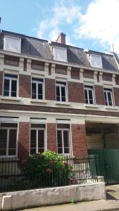 a brick house with a green door and a fence at Apt 2 du Temple HyperCentre & Parking in Cambrai