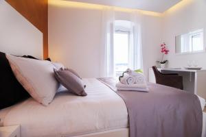 1 dormitorio con 1 cama con sábanas y almohadas blancas en Luxury rooms Skystar-Split, en Split