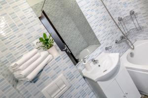 La salle de bains est pourvue d'un lavabo, de toilettes et d'une baignoire. dans l'établissement ConceptHT Regim Hotelier, à Iaşi