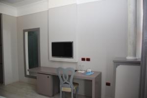 a room with a desk with a tv and a chair at Te Stela Resort & SPA in Tirana