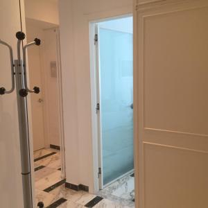 een glazen douchedeur in een badkamer met een tegelvloer bij Giusy near the sea in Sanremo