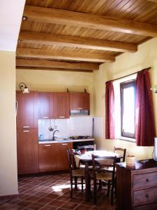 uma cozinha com mesa e cadeiras num quarto em Il Ritrovo degli Angeli em San Mauro Cilento