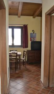 uma sala de jantar com uma mesa e uma televisão em Il Ritrovo degli Angeli em San Mauro Cilento