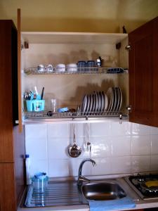 una cocina con fregadero y un estante con platos en Il Ritrovo degli Angeli, en San Mauro Cilento