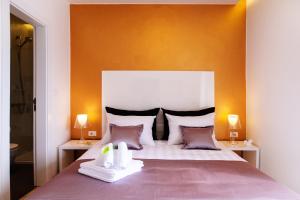 1 dormitorio con 1 cama grande y pared de color naranja en Luxury rooms Skystar-Split, en Split