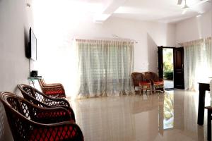 a living room with chairs and a table at Coffee Native - A Family Homestay in Mudigere