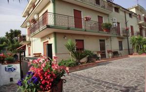 a building with a bunch of flowers in front of it at B&B La Porta Del Cilento in Capaccio-Paestum