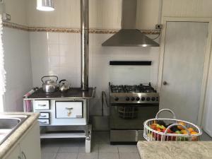 a kitchen with a stove and a basket of fruit at Casa Florecer in Contulmo