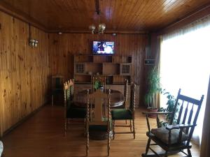 a dining room with a table and a tv on a wall at Casa Florecer in Contulmo