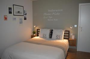 a bedroom with a bed with a sign on the wall at Maison Margriet in Tongeren