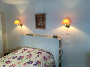 - une chambre avec deux lumières sur le mur et un lit dans l'établissement Appartements RESIDILAVERDE Hypercentre, à Grenoble
