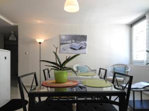 une salle à manger avec une table, des chaises et une plante dans l'établissement Appartements RESIDILAVERDE Hypercentre, à Grenoble