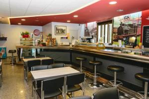 a restaurant with a bar with chairs and tables at Hotel Estació in Olot