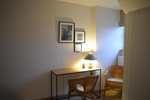 a room with a desk with two chairs and a lamp at Maison Margriet in Tongeren
