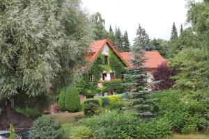 リップシュタットにあるHotel-Pension Haus Holtdirkのオレンジの屋根と庭園のある家