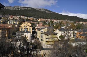 Une ville avec des maisons et une montagne en arrière-plan dans l'établissement Hotel Tres Arcos, à San Lorenzo de El Escorial