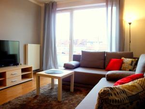 livingROOM_Wroc_Mosiężna في فروتسواف: غرفة معيشة مع أريكة ونافذة كبيرة