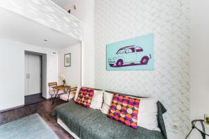 a living room with a couch and a painting of a car at Erzsébet Apartmanok in Budapest