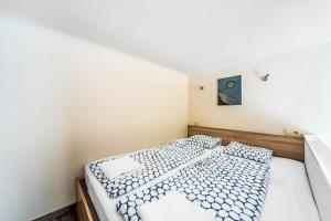 1 dormitorio con 1 cama con sábanas y almohadas blancas en Erzsébet Apartmanok, en Budapest