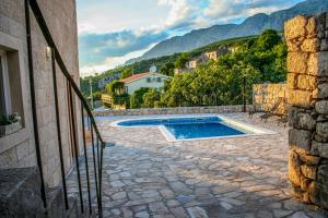 a swimming pool in a patio with mountains in the background at Villa Ursula in Podgora