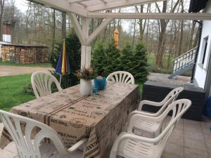 ein Tisch und weiße Stühle auf einer Terrasse mit Tisch und Stuhlplatte in der Unterkunft Ferienwohnung Rosi Stoppa in Burg