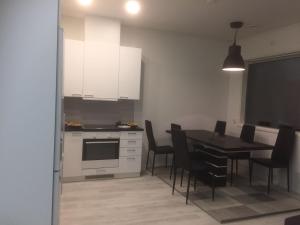 eine Küche und ein Esszimmer mit einem Tisch und Stühlen in der Unterkunft Aurora Apartment Inari in Inari