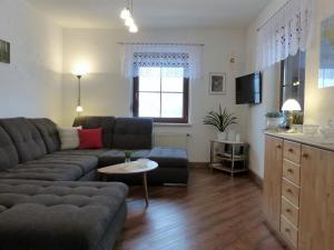 a living room with a couch and a table at Cozy Apartment in Ore Mountains with Balcony in Breitenbrunn