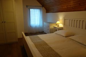 a bedroom with a large white bed and a window at Apartment Makuc in Bovec