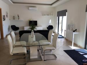 a dining room with a glass table and chairs at Casa De Estrelas in São Brás de Alportel