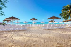 a group of chairs and umbrellas on a beach at Bougainvillea Barbados in Christ Church