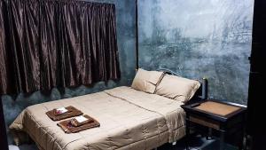 una camera da letto con un letto con due vassoi sopra di ฺBaan Tonglong Homestay a Hang Dong