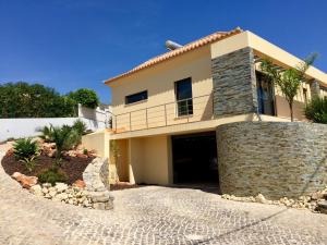 a large house with a stone wall at Casa De Estrelas in São Brás de Alportel