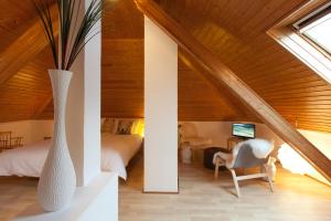 Zimmer im Dachgeschoss mit einer Vase und einem Schlafzimmer in der Unterkunft Haus am Giebel in Heimbach