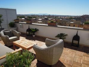 a patio with chairs and a table on a roof at Penthouseinrome in Rome
