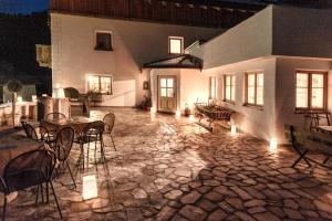 a patio with tables and chairs and a building at Messnerwirt Onach in San Lorenzo di Sebato