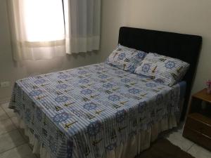Una cama con edredón en un dormitorio en Apartamento Maravilhoso, en Guarujá