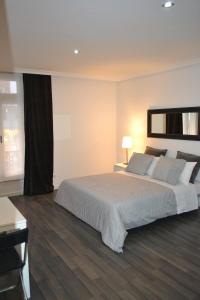 マドリードにあるルーム グラン ビア アパートメントのベッドルーム(大きな白いベッド1台、窓付)
