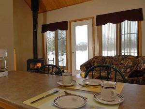 a kitchen with a table with plates and a stove at Le Genevrier in Baie-Saint-Paul