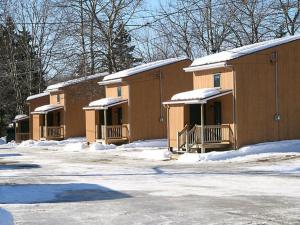 a row of brown buildings with snow on them at Le Genevrier in Baie-Saint-Paul
