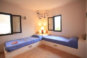 two beds in a room with two windows at Daniela in Sant Francesc Xavier +34 photos