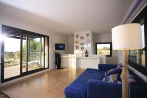a living room with a blue couch and a sliding glass door at Daniela in Sant Francesc Xavier