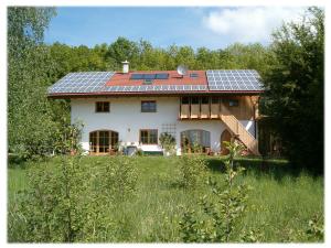 una casa con pannelli solari sopra di essa di Ferienwohnung Bacher a Edling