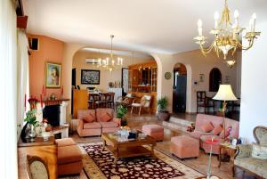 a living room with pink furniture and a chandelier at Villa Katerina-Despina in Argoulidhés
