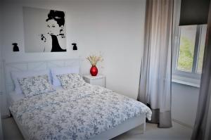 a white bedroom with a bed and a window at Vlatkovićeva Apartments in Senj