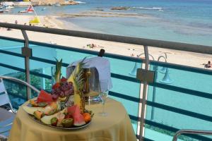 トッレ・サンタ・サビーナにあるHotel Mirageのビーチの景色を望むテーブル(フルーツプレート付)